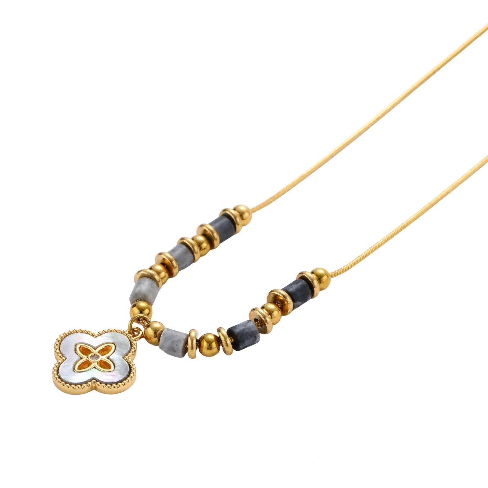 Gold-toned beaded necklace with grey stones and quatrefoil abalone shell pendant on cream background.