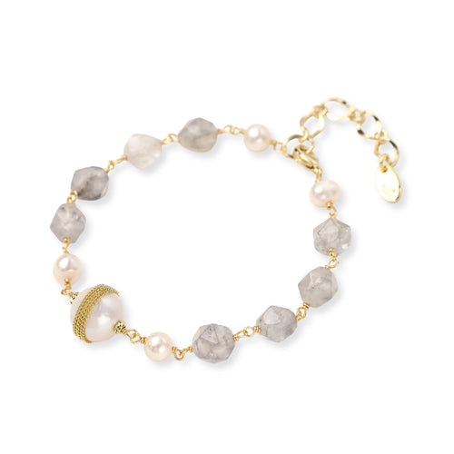 Bracelet with cloudy quartz beads, freshwater pearls, and gold-wrapped baroque pearl centerpiece on white background.